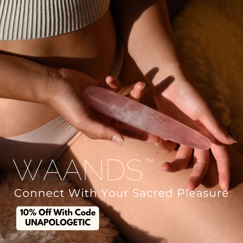Close up of woman's lower belly, tan underwear, and thigh with her hands holding a slim rose quartz yoni wand from Waands Crystal Pleasure Tools with a discount code of "UNAPOLOGETIC" for 10% off